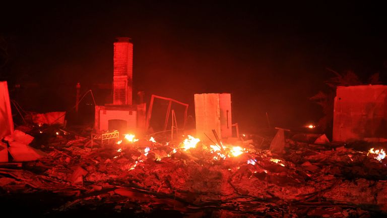 Flames rise from damaged property, as smoke billows from the Mountain Fire in Camarillo, California, U.S., November 6, 2024. REUTERS/David Swanson