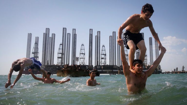 Teenagers of a kickboxing school attend a training session at a beach on the Caspian Sea in Baku, Azerbaijan, Saturday, June 27, 2015, with Soviet era oil platforms in the background. The 2015 European Games are being held in Baku until June 28. (AP Photo/Dmitry Lovetsky)