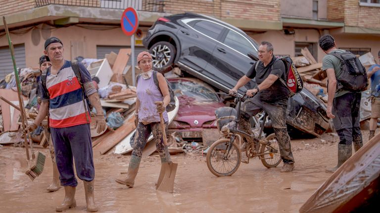 People walk through an area affected by floods in Catarroja, Spain.
Pic: AP