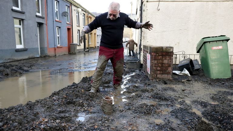 Resident Rob Scholes, 75, moves through mud at the site of a mudslide, in the aftermath of Storm Bert, in Cwmtillery, South Wales, Britain, November 25, 2024. REUTERS/Hollie Adams
