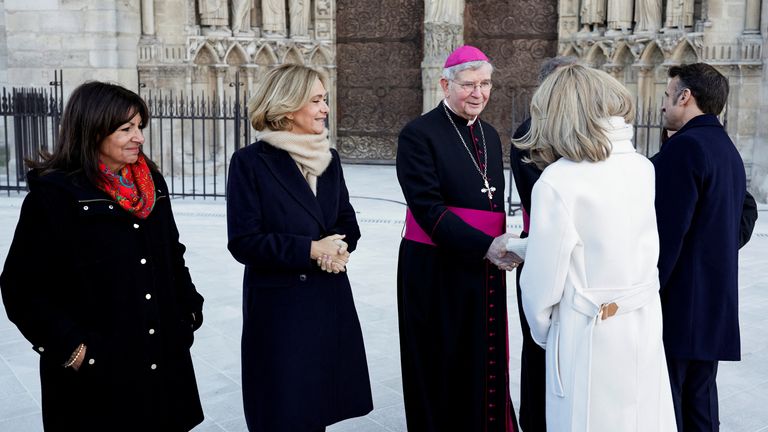 Brigitte Macron (2R) greets Paris' archbishop Laurent Ulrich (C) next to Paris' mayor Anne Hidalgo (L) Ile-de-France's President Valerie Pecresse and French President Emmanuel Macron (R) during a visit to Notre Dame de Paris Cathedral in Paris, on November 29, 2024. The Notre Dame Cathedral is set to re-open early December 2024, with a planned weekend of ceremonies on December 7 and 8, 2024, five years after the 2019 fire which ravaged the world heritage landmark and toppled its spire. Some 250 