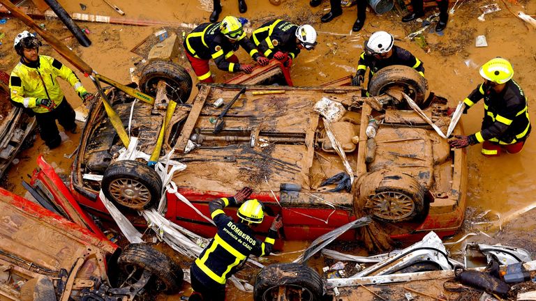 Firefighters search for possible victims inside a car in Alfafar, Valencia, yesterday. Pic: Reuters