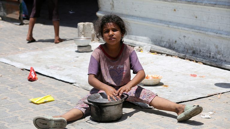 A girl sits on the ground near a charity kitchen in Khan Younis, Gaza. Pic: Reuters