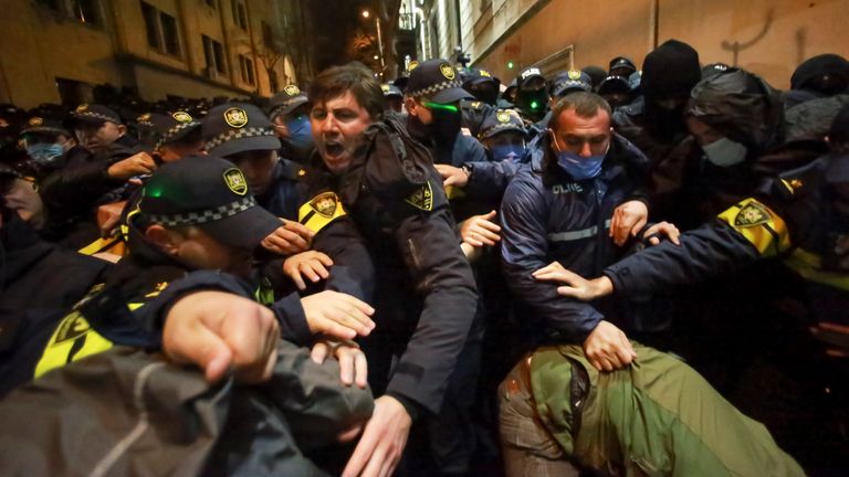 Police try to push out protesters after they pour into the streets following Georgian Prime Minister Irakli Kobakhidze's announcement, rallying outside the parliament building in Tbilisi, Georgia, on Thursday, Nov. 28, 2024. (AP Photo/Zurab Tsertsvadze)