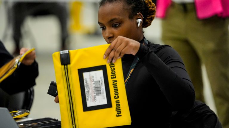 A Fulton County election worker scans votes in Georgia. Pic: AP