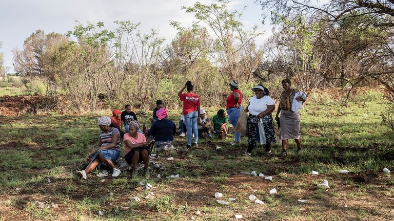 Relatives of miners and community members wait at a mine shaft where the estimated 4000 illegal miners  are refusing to leave.
Pic: AP