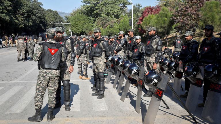 Police in riot gear stand guard alongside a road to prevent an anti-government rally by supporters of Imran Khan in Islamabad.
Pic: Reuters