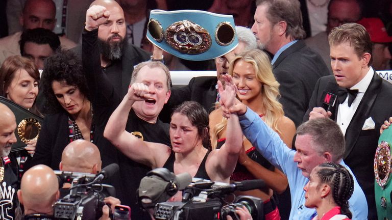 Katie Taylor, center, celebrates after defeating Amanda Serrano during their undisputed super lightweight title bout, Friday, Nov. 15, 2024, in Arlington, Texas. (AP Photo/Julio Cortez)