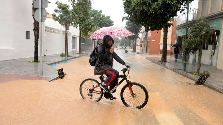 A cyclist crosses a road after the Campanillas river overflows in the Campanillas neighbourhood, after Spanish meteorological agency AEMET issued red alerts due to expected heavy rains, in Malaga,
Pic: Reuters