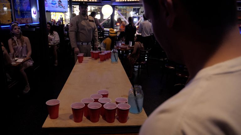 Two roommates playing beer pong - one supports Mr Trump while the other is undecided