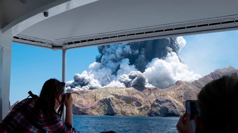 Tourists look at the eruption of the volcano on White Island in December 2019. Pic: AP
