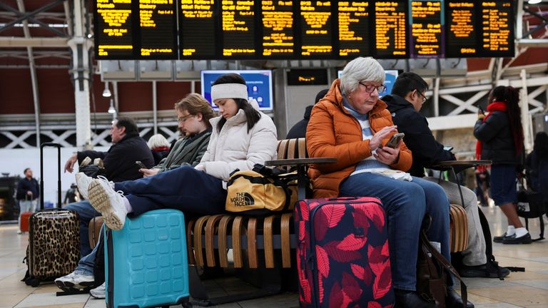 Rail passengers wait with their luggage following train cancellations caused due to Storm Bert on a screen at Paddington Station.
Pic: Reuters