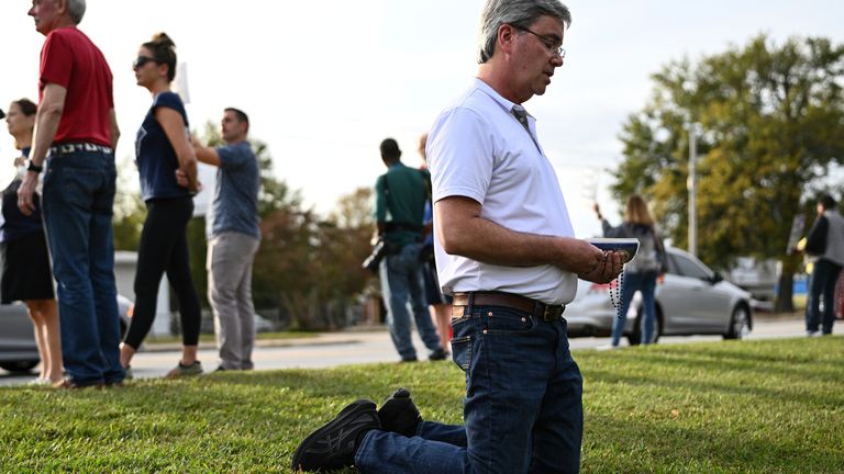 A protestor kneels to pray outside the prison. Pic: AP