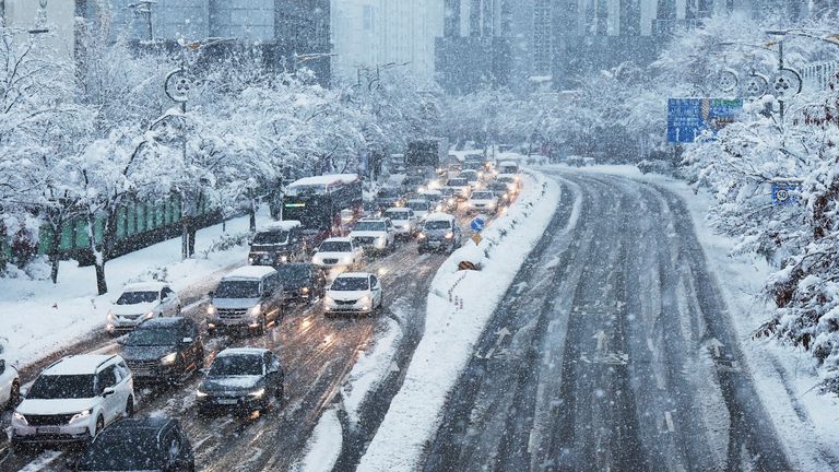 Cars move slowly on a road during heavy snowfall in Suwon, South Korea, Thursday, Nov. 28, 2024. (Hong Ji-won/Yonhap via AP)