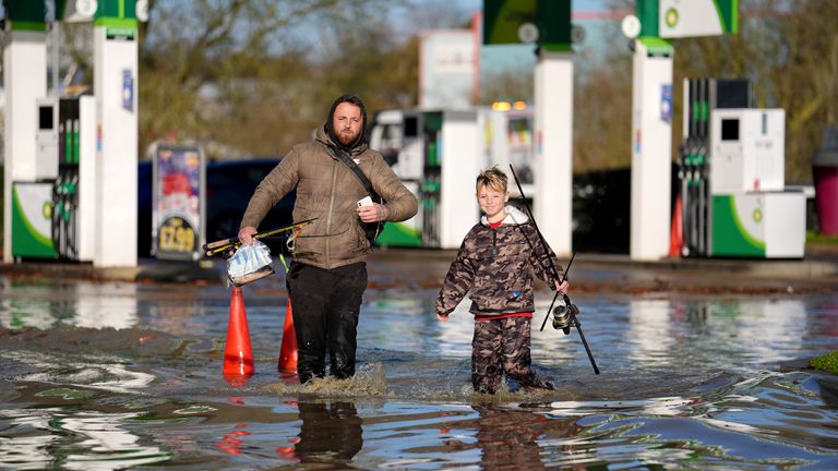 People walk through floodwater near the Billing Aquadrome in Northamptonshire. Storm Bert will continue to bring disruption into Monday after torrential downpours caused "devastating" flooding over the weekend. Picture date: Monday November 25, 2024. PA Photo. See PA story WEATHER Bert. Photo credit should read: Jordan Pettitt/PA Wire