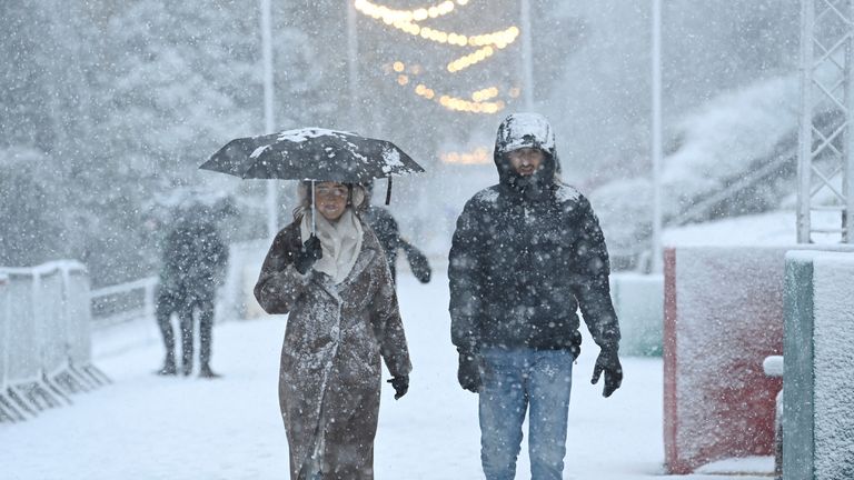 People walk through the snowfall during Storm Bert, along Princes Street Gardens in Edinburgh, Scotland, Britain, November 23, 2024. REUTERS/Lesley Martin