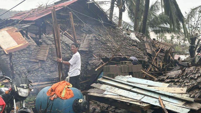 In this photo provided by the MDRRMO Viga Catanduanes, a resident stands beside a damaged house caused by Typhoon Man-yi in Viga, Catanduanes province, northeastern Philippines Sunday, Nov. 17, 2024. (MDRRMO Viga Catanduanes via AP)