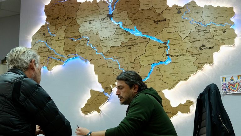 Serhiy Prytula in front of a wood-carved and illuminated map of Ukraine