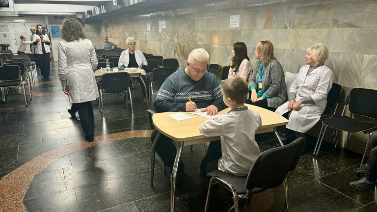 Dmytro Mitelyov (centre), the neurologist on duty monitoring the children as they spend large parts of their days underground, speaks to a child