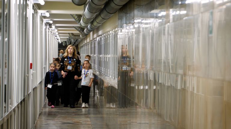 The children being led down a corridor in their makeshift school