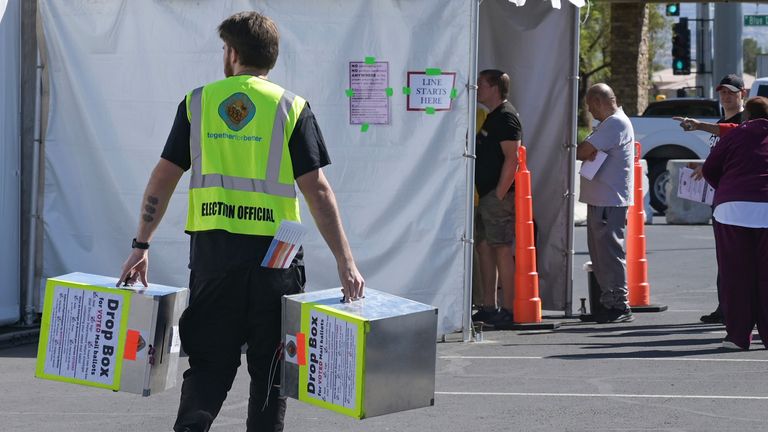 An official carries drop boxes to a polling place in Las Vegas on 19 October. Pic: AP