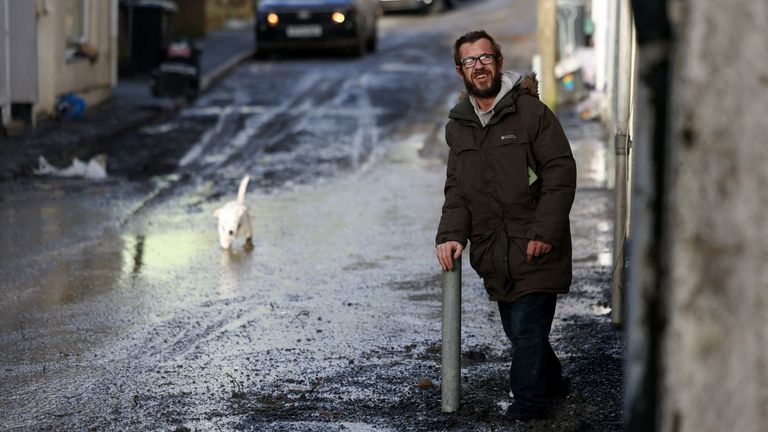 A resident and a dog move mud through mud in Cwmtillery, Wales.
Pic: Reuters