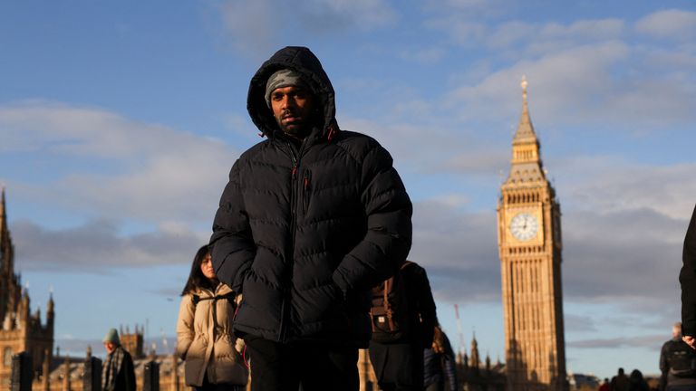 Commuters dressed in warm clothes walk over Westminster Bridge.
Pic: Reuters