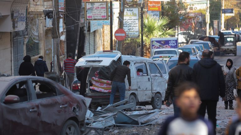 People walk past a damaged site in Aleppo. Pic: Reuters