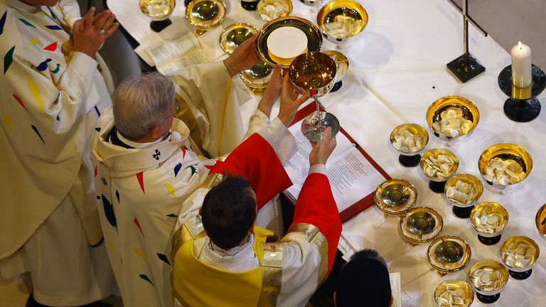 Archbishop Laurent Ulrich, center, leads the Eucharist surrounded by clergy members after the consecration of the altar during the inaugural Mass to mark the Cathedral's reopening after its restoration, in Paris, France, Sunday, Dec. 8, 2024. (Sarah Meyssonnier/Pool Photo via AP)