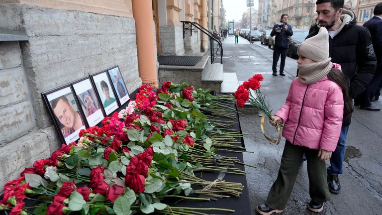 People lay flowers at the Consulate of Azerbaijan in the memory of victims of the Azerbaijan Airlines' Embraer 190 that crashed near the Kazakhstan's airport of Aktau, in St. Petersburg, Russia, Thursday, Dec. 26, 2024. (AP Photo/Dmitri Lovetsky)