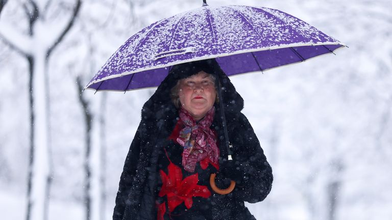 A woman walks through the park during heavy snowfall in Sarajevo, Bosnia, Tuesday, Dec. 24, 2024. (AP Photo/Armin Durgut)