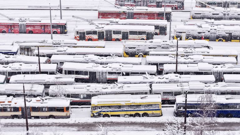 An aerial view of parked trolley buses during heavy snowfall in Sarajevo, Bosnia, Tuesday, Dec. 24, 2024. (AP Photo/Armin Durgut)