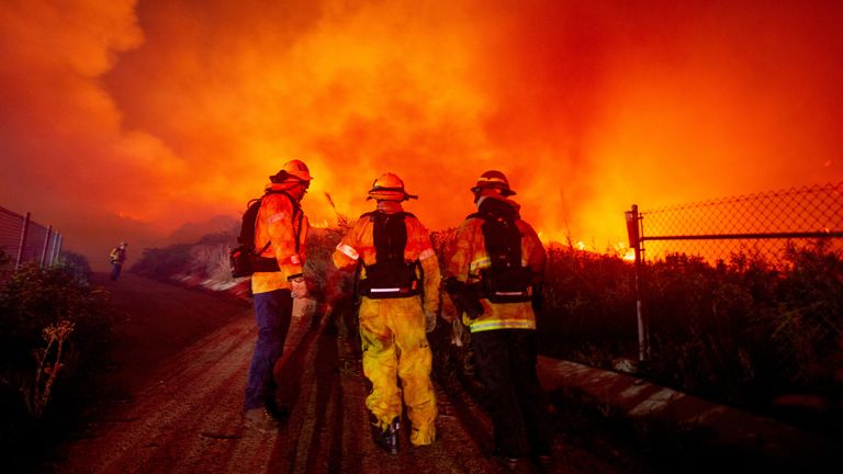 Firefighters watch as the Franklin Fire burns in Malibu, California, U.S., December 10, 2024. REUTERS/Ringo Chiu

