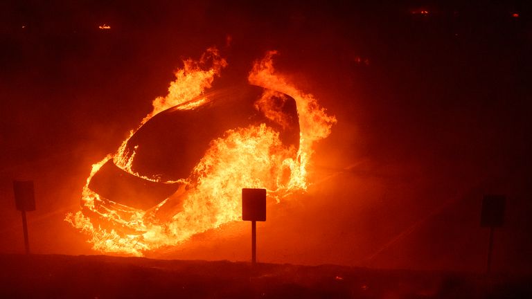 A vehicle burns during the Franklin Fire on the campus of Pepperdine University in Malibu, Calif., Tuesday, Dec. 10, 2024. (AP Photo/Eric Thayer)