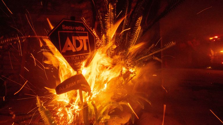 A sign burns as firefighters battle the Franklin Fire in Malibu, California.
Pic: AP