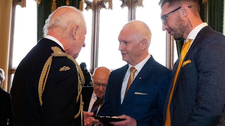 King Charles III presents an Elizabeth Emblem to Bryndon Hughes (centre), for Police Constable Nicola Hughes who served with Greater Manchester Police, during the inaugural presentation ceremony at Windsor Castle, Berkshire. Aaron Chown/PA Wire