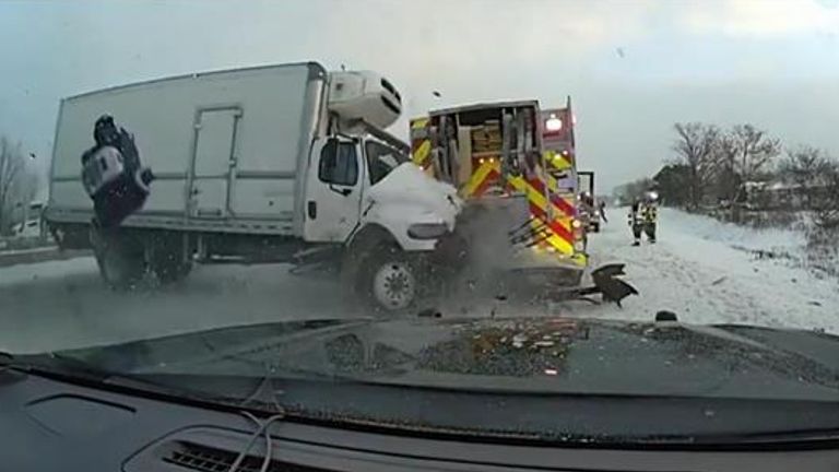 Police footage shows the moment a truck smashed into the side of a fire engine that was responding to a separate collision on the motorway. 