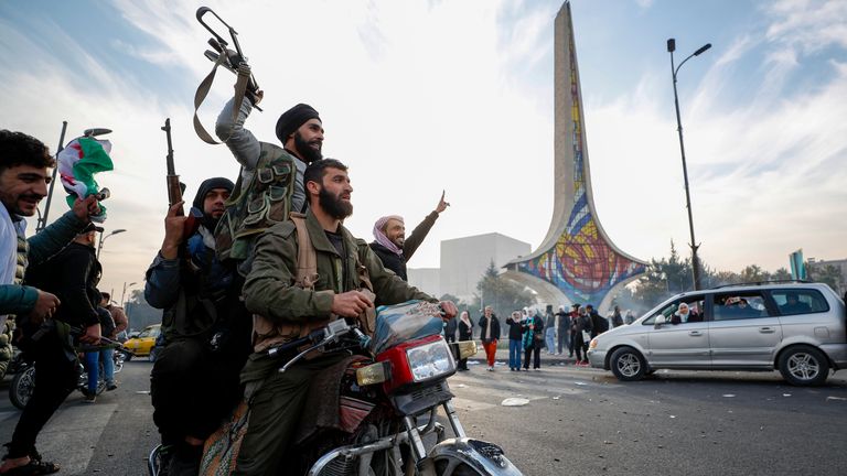 Syrian opposition fighters celebrate the fall of the Syrian government, in Damascus, Syria, Sunday, Dec. 8, 2024. (AP Photo/Omar Sanadiki)