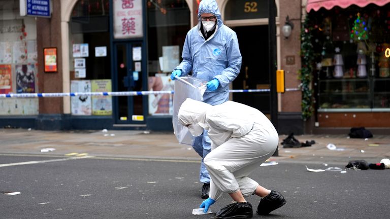 Forensic investigators collect evidence at the scene on Shaftesbury Avenue.
Pic: PA
