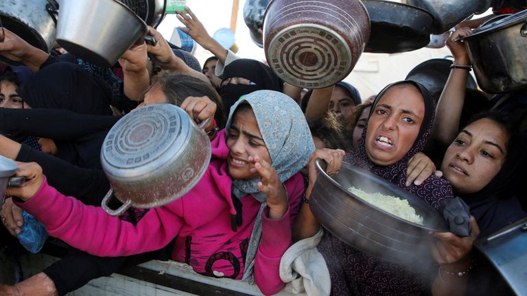 Palestinians gather to receive food cooked by a charity kitchen, amid a hunger crisis, as the Israel-Gaza conflict continues, in Khan Younis in the southern Gaza Strip, November 19, 2024. REUTERS/Hatem Khaled TPX IMAGES OF THE DAY