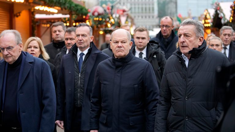 The Chancellor of Germany Olaf Scholz, center, visits a Christmas Market, where a car drove into a crowd on Friday evening, in Magdeburg, Germany, Saturday, Dec. 21, 2024. (AP Photo/Ebrahim Noroozi)