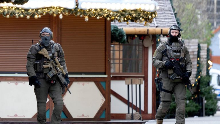 Police officers walk through the Christmas market in Magdeburg. Pic: Reuters