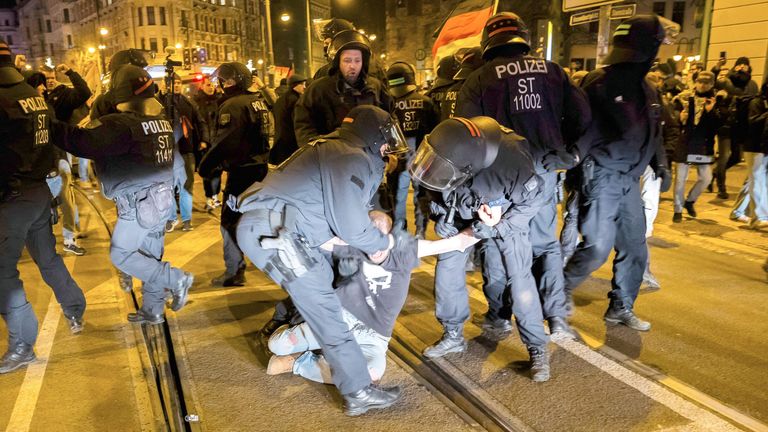 A man is taken away by police officers during a demonstration by right-wing groups. Pic: AP