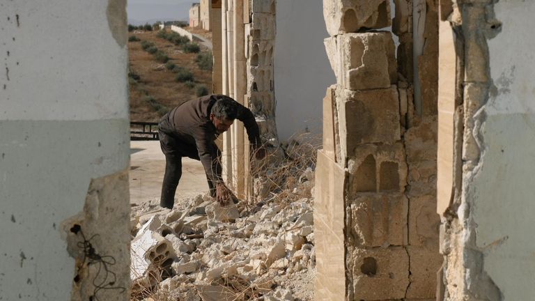 A man sifts through rubble in Idlib