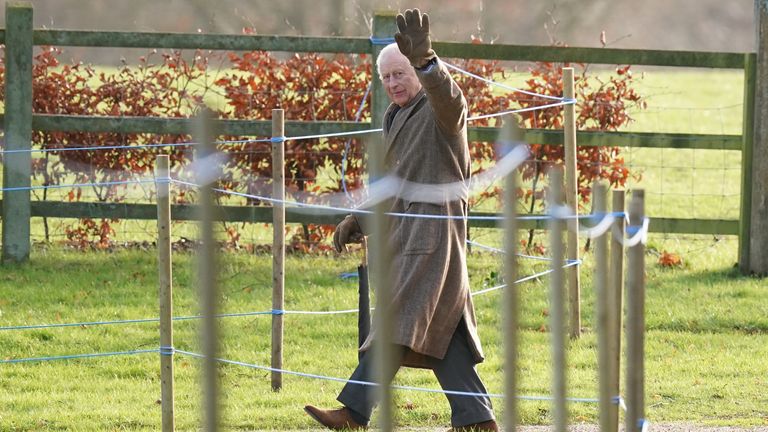 The King waves as he walks to church in Norfolk. Pic: PA