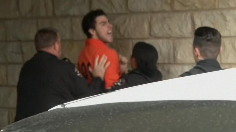 Luigi Mangione struggling as he appears in Blair County Courthouse for an extradition proceeding. APTN live screengrab