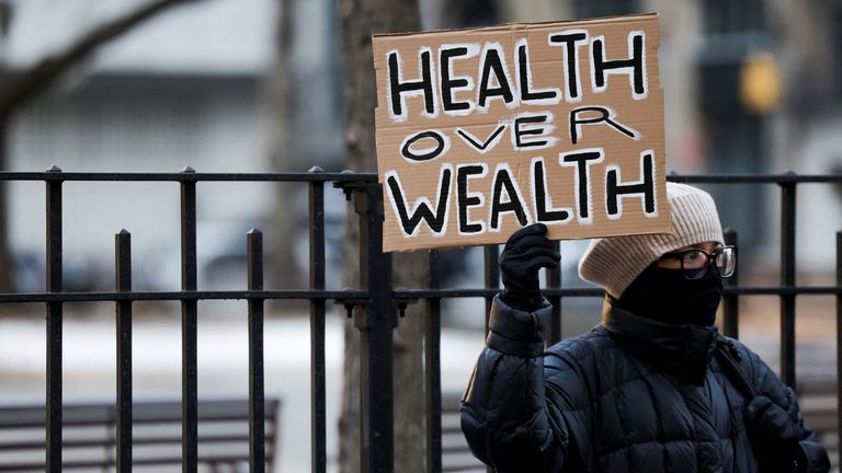 A person holds a placard outside New York Supreme Court, on the day of an arraignment hearing for Luigi Mangione, the suspect in the killing of UnitedHealth Group chief executive Brian Thompson, in New York City, U.S. December 23, 2024. REUTERS/Kent Edwards

