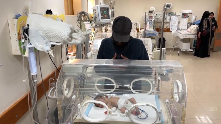 Yahia al Batran standing over his surviving son in hospital