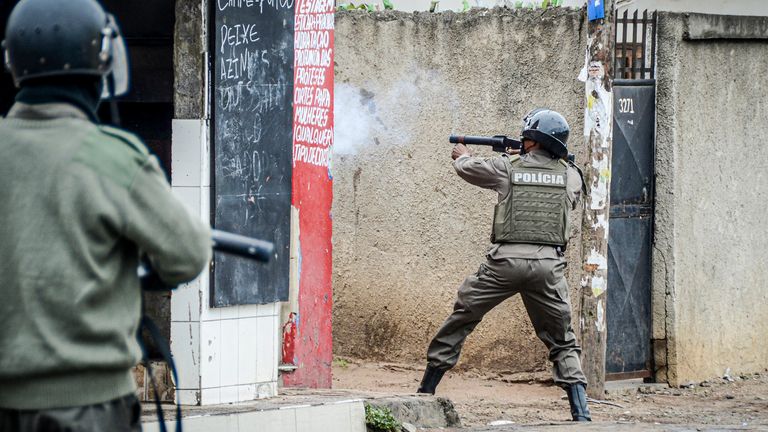 A police officer aims his weapon at protesters in Maputo, Mozambique, Thursday, Nov. 7, 2024. Protesters dispute the outcome of the Oct. 9 elections that saw the ruling Frelimo party extend its 49-year rule. (AP Photo/Carlos Uqueio, File)