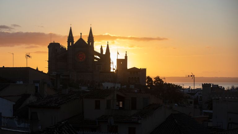 21 December 2024, Spain, Palma: Locals and tourists meet at dawn to watch the sunrise with a view of the cathedral on the day of the winter solstice. Photo by: Clara Margais/picture-alliance/dpa/AP Images